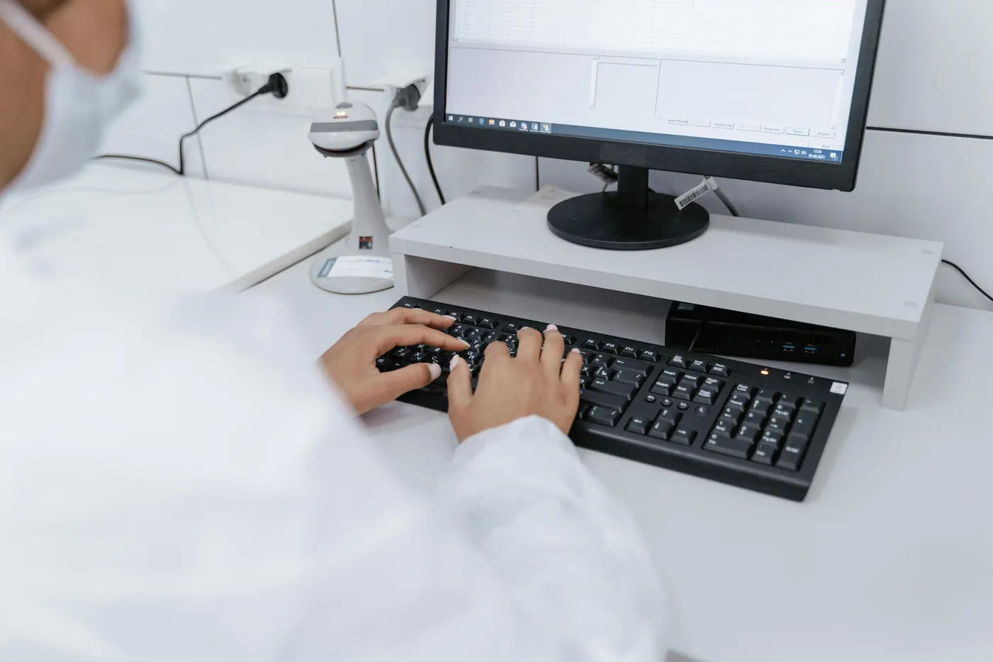 Healthcare practice staff member at a computer managing practice settings